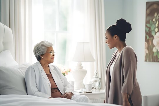 African american woman Doctor talking to a senior woman in bedroom modern white home