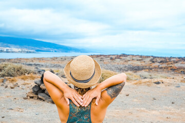Woman viewed from back enjoy nature and scenic place with coastline and blue sky in background....