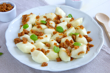 Lazy dumplings - a traditional Polish dish made of cottage cheese, potatoes, flour and eggs served with breadcrumbs fried in butter