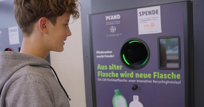 Teenager recycling plastic bottle at automatic machine collector in exchange for money. Plastic bottle recycling machine. Ecology concept. Recycling. Refund and recycling of plastic bottles