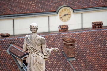 Abstract photo of checking time. The statue is looking at the wall clock.