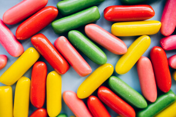 Mixed collection of colorful candy on blue background. Flat lay, top view