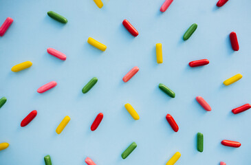 colorful sprinkles, candy pattern over blue background, decoration for cake and bakery