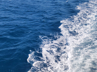 Fototapeta na wymiar blue sea water with white foam from boat