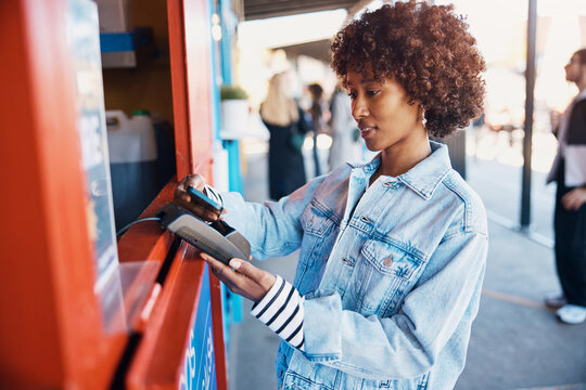 Smiling woman paying for her food truck purchase with her smart phone