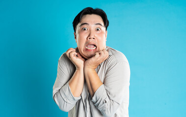 Portrait of an Asian guy posing on a blue background