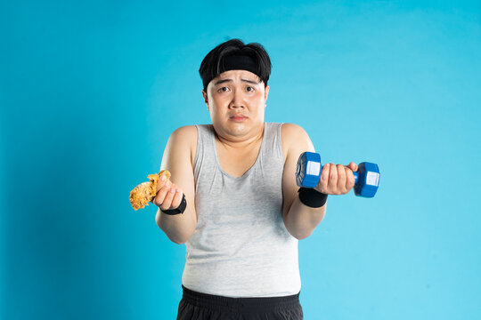 Image of Asian man exercising on blue background