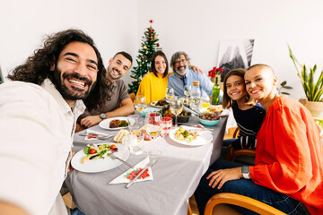 Happy multi generational family taking selfie portrait together sitting on table at dinner christmas celebration