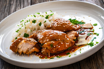 Hawaiian chicken style - shoyu chicken thighs with white rice on wooden table
