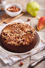 Chocolate sponge cake with pears and hazelnuts. Delicious autumn homemade sweet pie with seasonal fruits. 