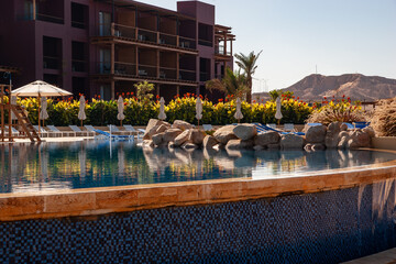 Fototapeta premium Hotel Movenpick Resort and SPA Tala Bay Aqaba 5 stars on the Red Sea in Jordan. Hotel area with many pools surrounded by palm trees. Aqaba, Jordan - December 06, 2009