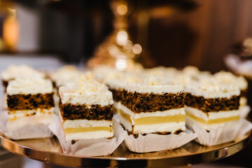 Candy bar with dessert for celebrating birthday, baptism. Decorated delicious. Sweet table. Plates of cakes and muffins. Table with sweets, buffet. Dessert table for party goodies for wedding. Closeup