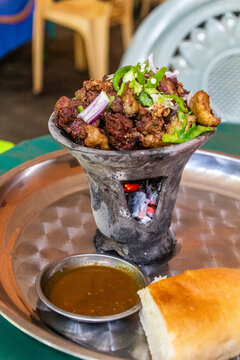 Beef tibs being prepared on a traditional server over hot charcoal in a restaurant in Jinka, Ethiopia