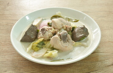 spicy boiled chicken meat and blood with slice cabbage in coconut milk soup or Tom Kha Kai soup Thai food on plate