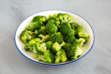 Homemade Pan-fried Broccoli on a Plate on a gray background, side view.