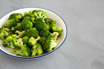 Homemade Pan-fried Broccoli on a Plate on a gray background, side view. Copy space.