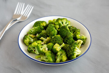 Homemade Pan-fried Broccoli on a Plate on a gray background, side view.