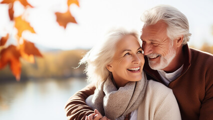 freudig lachende lebensfrohe zufriedene Senioren umarmen sich im Herbst