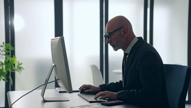 オフィスでパソコンを使って作業する外国人ビジネスマン