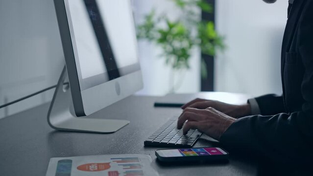 オフィスでパソコンを使って作業するビジネスマン