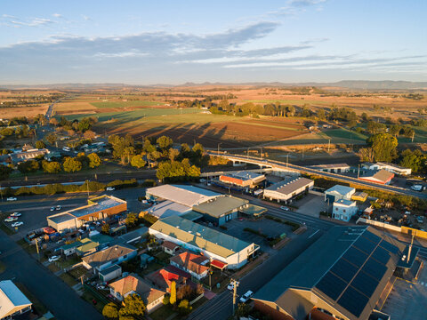 Morning light and long shadows on edge of town with bridge over train track