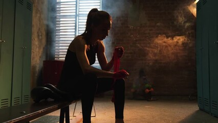 Women self defense girl power. Woman fighter preparing for fight wrapping hands with red boxing wraps sports protective bandages. Strong girl ready for fight active exercise sparring workout training