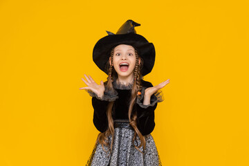 A funny and joyful child in a Halloween costume, on an isolated yellow background. A happy little...