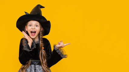 A surprised girl in a witch's fancy dress points to the side at the advertisement and the ad, the place for advertising in the photo with an attractive witch, a funny witch points to the sign.