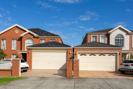 garages with roller doors and brick suburban homes in sunlit built close together