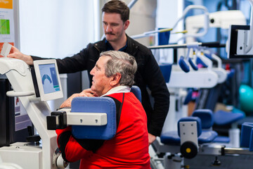 physiotherapist chatting with client using exercise therapy equipment