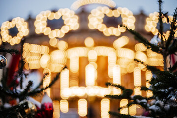 Out of focus is a blurry large carousel with lights. Beautiful Christmas background with space for text and greetings