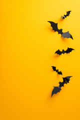 Stir excitement for your Halloween party using this concept. Visualize vertical top view setup with creepy bats on a yellow backdrop, open for your content