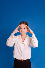 student teen girl holding head in hands over blue background. problem of choice and decision-making concept