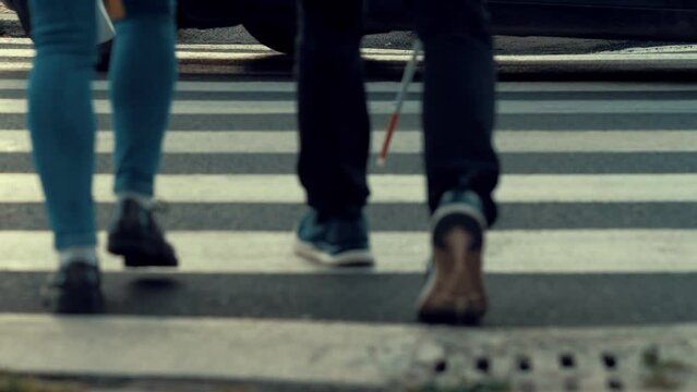 blind man crosses the street in the traffic helped by a friend-blurred