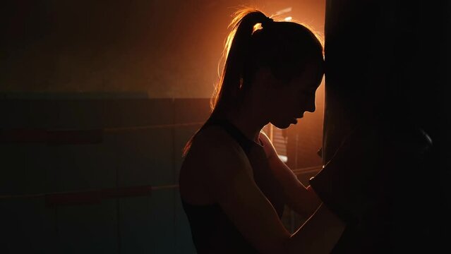 Women self defense girl power. Strong woman fighter resting after fight training on boxing ring. Strong girl tired after punching boxing bag. Training day in gym. Strength fit body workout training