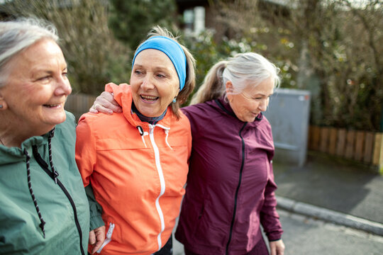 Senior group of female friends jogging and exercising in the suburbs