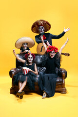 Halloween Family. Happy, excited father, mother and children in halloween skeleton spooky makeup watching films with pop corn.