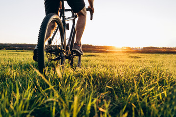 Naklejka premium low angle view of cyclist riding mountain bike on rocky trail at sunrise