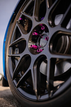 Close-up of black alloy wheel with purple details