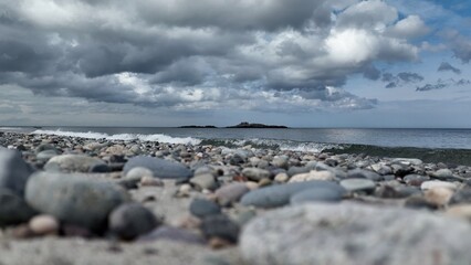 Ocean waves and surf breaking on pebble beach