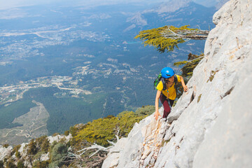 climber goes along the rocky ridge. girl climbing in the mountains. the concept of adventure and...