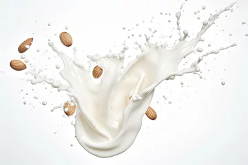 Rolgordijnen Splash of almond milk in the air with almond nuts on a white background. © OleksandrZastrozhnov