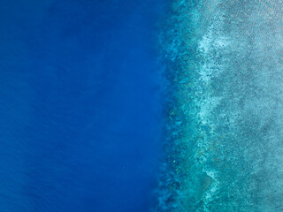 Aerial bird's eye view of the reef crest, edge or border between the open blue ocean and the protected, turquoise part of the reef. Hayman Island, Whitsunday Islands, Queensland, Australia.