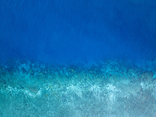 Aerial bird's eye view of the reef crest, edge or border between the open blue ocean and the...