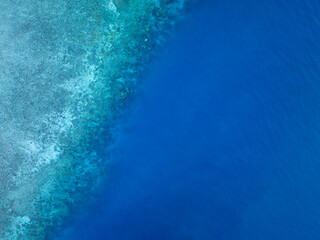 Fototapeta na wymiar Aerial bird's eye view of the reef crest, edge or border between the open blue ocean and the protected, turquoise part of the reef. Hayman Island, Whitsunday Islands, Queensland, Australia.