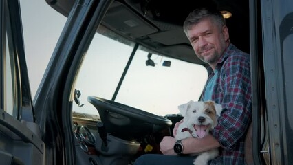 Portrait of A professional trucker sit in a semi truck along with the dog. Close up shot