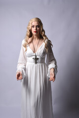 Close up portrait of beautiful blonde model wearing elegant  white halloween gown, a historical...
