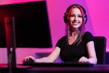 Professional smiling esport gamer girl playing online video game on PC © kjekol