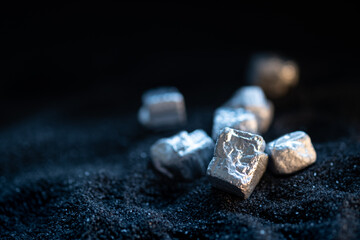 Pure silver or platinum or rare earth from the mine that was placed on the black sand - obrazy, fototapety, plakaty