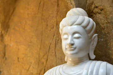 Fototapeta na wymiar The face of a white stone Buddha